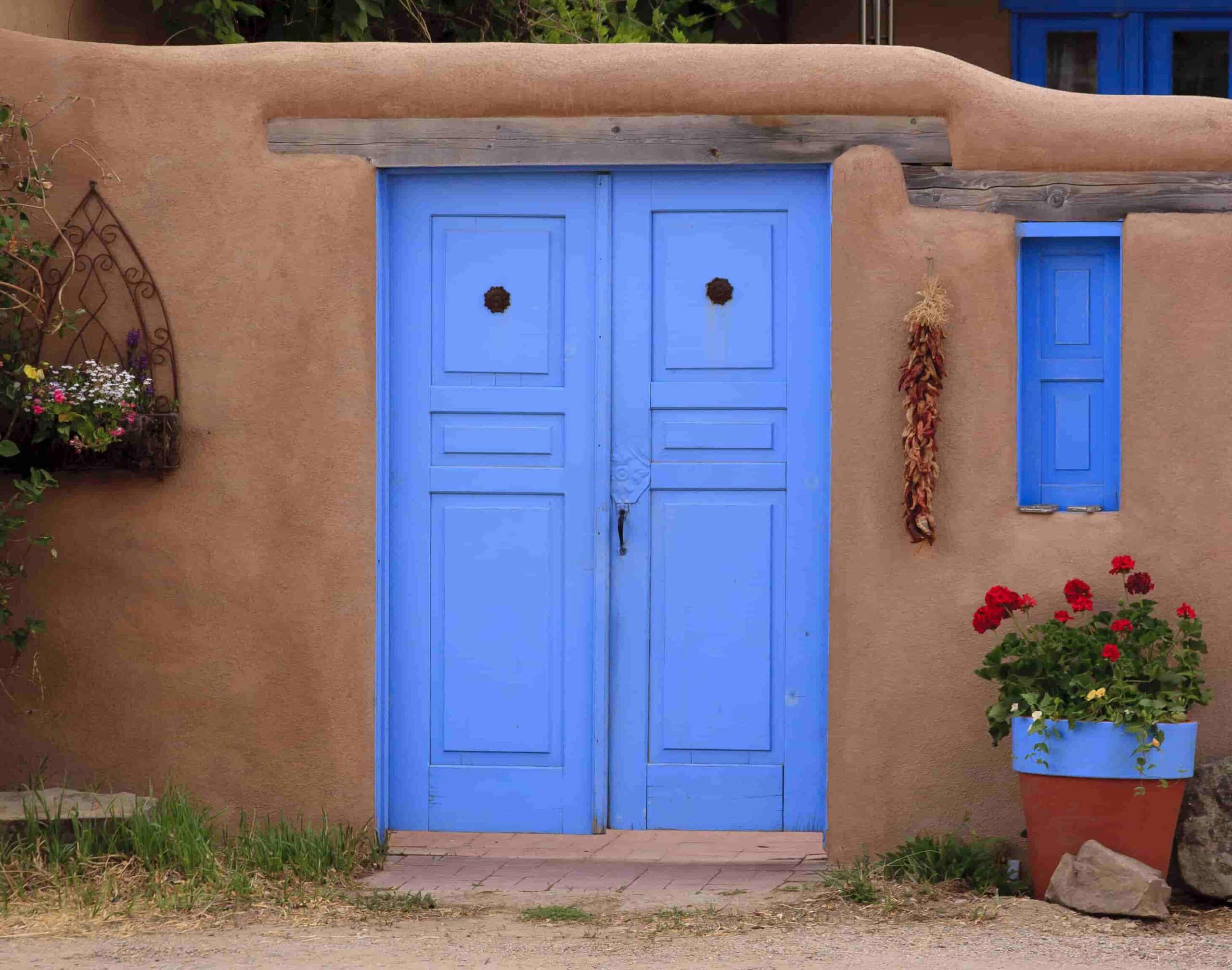 Traditional Adobe Wall with a Bright Blue Wooden Door and Window