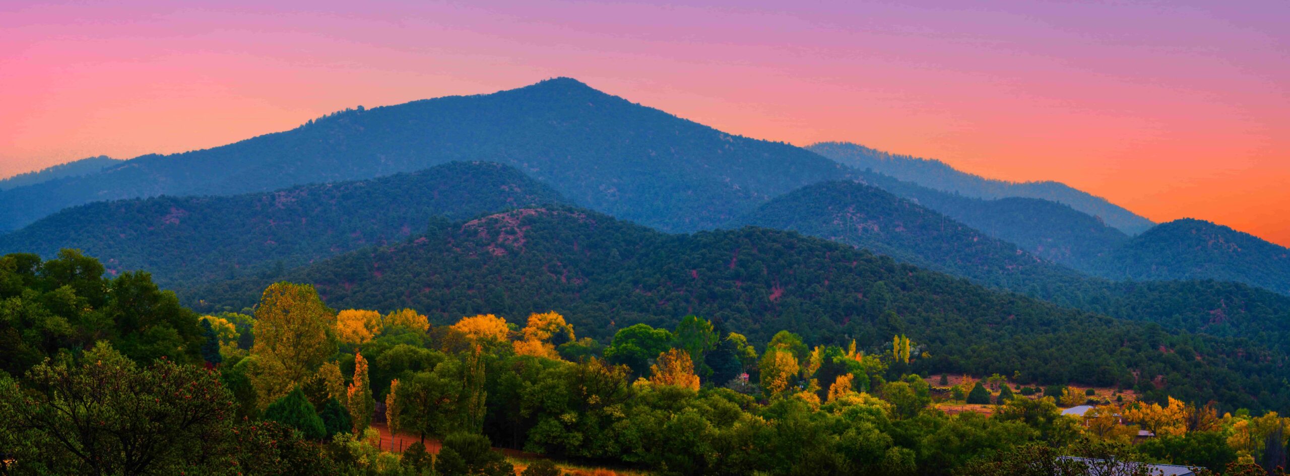 Colorful Mountain Landscape at Sunset with Forested Hills